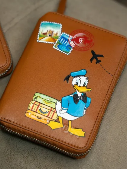 A close-up of the Donald Duck passport cover, ready for takeoff.