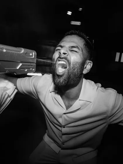 A guest having the time of his life with a money gun. This dynamic, black and white shot is all about capturing the peak energy and playful madness of the party.