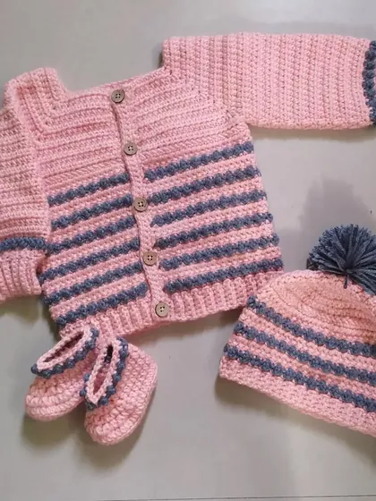 I love creating complete, coordinated outfits. This cozy winter set includes a striped cardigan with wooden buttons, a matching pom-pom beanie, and a pair of adorable booties, all handmade to keep your baby warm and stylish.