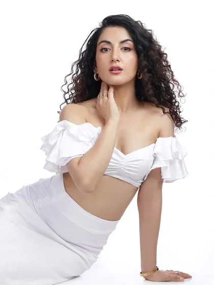 A clean, high-key portrait of a model in a white off-the-shoulder top against a pure white background, creating a fresh and modern feel.