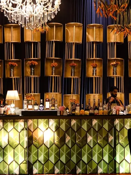 A wide shot of the impressive bar setup, showing the scale and detail. The wall of lamps behind the bar created a warm, golden glow that filled the space.