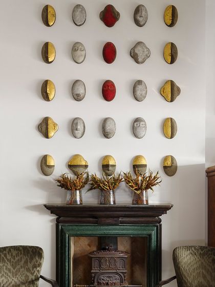 Above a Lutyens-style fireplace, we created an installation of ceramic masks. This collection adds a sculptural and textural element to the wall, showcasing our love for handcrafted, artisanal objects.