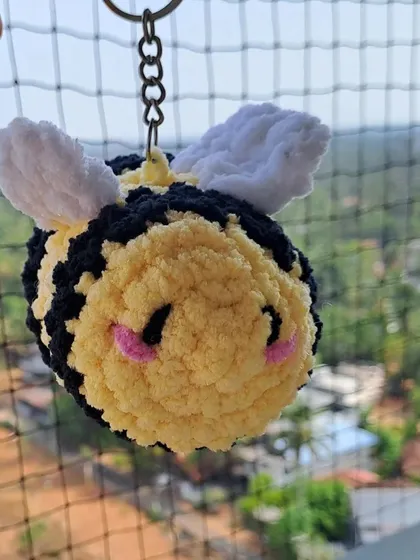Another shot of the plush bee keychain, showing its sweet expression and fluffy wings.