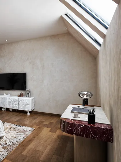 This angle shows the room's architecture, with a sloped ceiling and skylights. The red marble desk adds a pop of unexpected color.