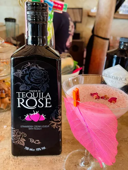 A creamy Tequila Rose cocktail garnished with a vibrant pink leaf. The color of the garnish perfectly complements the drink, creating a visually cohesive and appealing presentation.