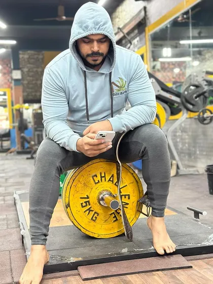 Resting on a weighted barbell between sets. The gym is my second home.