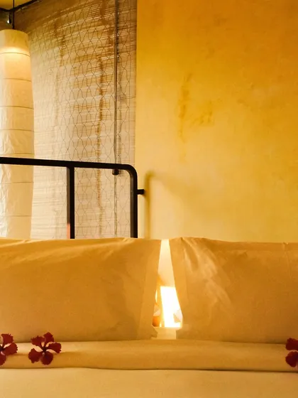 A close-up of the pillows on a bed, with fresh hibiscus flowers as a simple, elegant welcome gesture.