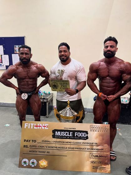 Posing with the prize money check and trophy. Success in bodybuilding is a team effort.