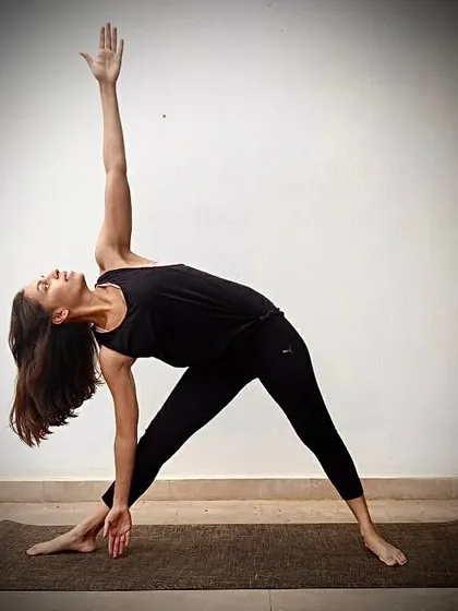 This image shows the full expression of Trikonasana. If you have neck problems or high blood pressure, I suggest modifications like looking down or straight ahead to practice safely.