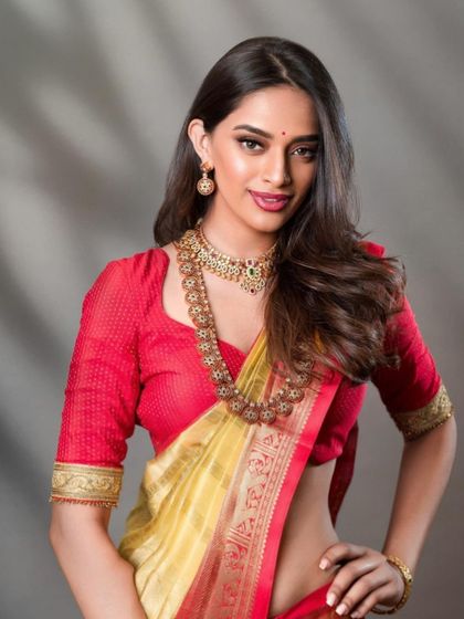 A modern South Indian bridal look, focusing on the intricate blouse embroidery and layered necklaces. The soft, diffused lighting creates a flattering portrait that is both contemporary and timeless.