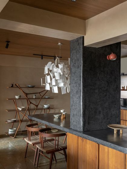 A structural column became a design opportunity for this cantilevered dining table. The monolithic form anchors the open-plan space, connecting the kitchen and dining areas while appearing to float effortlessly.