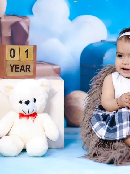 A close-up of the baby girl from the teddy bear theme, interacting with her fluffy friends.