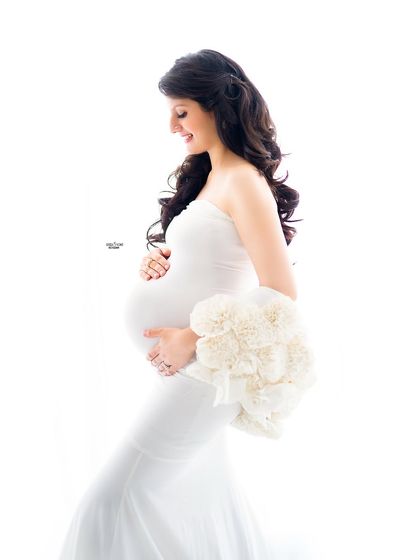 A joyful and classic high-key maternity pose. We'll focus on capturing genuine smiles and the happy anticipation of motherhood.