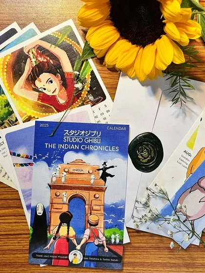 A flat lay of the Ghibli calendar goodies. You get the calendar pages, a cover page, bookmarks, and a wax-sealed envelope, all curated to create a magical unboxing experience.
