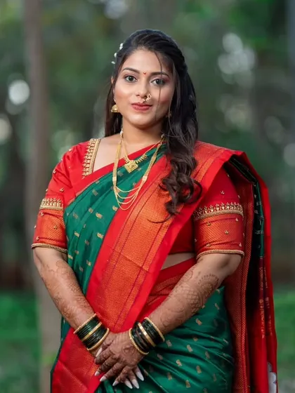 A beautiful portrait of the bride in her traditional green and red saree, a classic look for a Maharashtrian engagement or wedding.