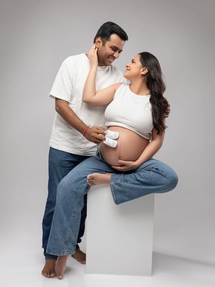 A playful and sweet moment, with tiny baby booties resting on the bump. It’s a lovely way to symbolize the little one on the way.