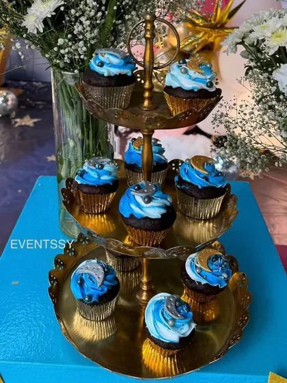 Galaxy-swirl cupcakes on a tiered golden stand, adding to the magical dessert spread.