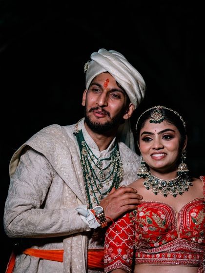 A candid moment between a North Indian couple on their wedding night, full of smiles and happiness.