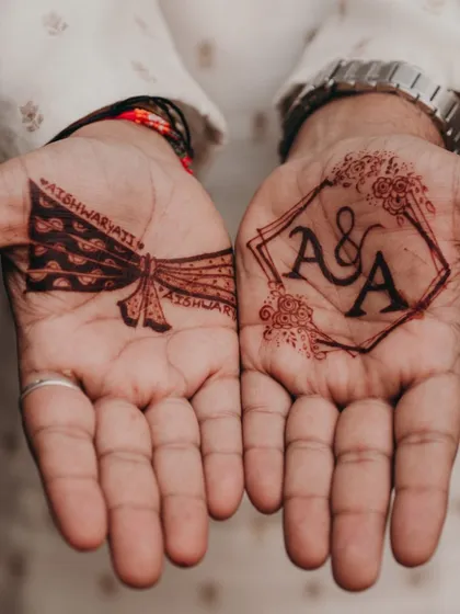 I love this combination of modern and traditional for a groom's mehendi. On one palm, we have a clean, geometric frame with the couple's initials, and on the other, a classic groom's turban design. It’s the perfect balance of personal and stylish.