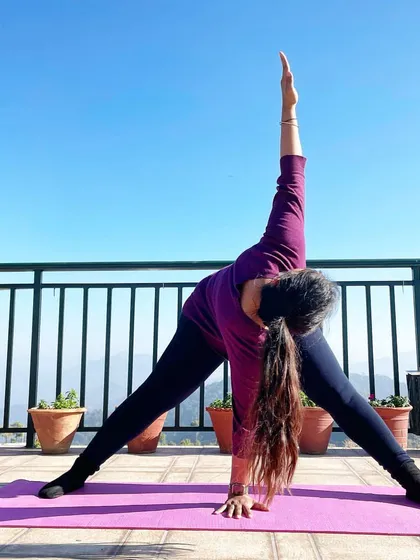 This is the Revolved Wide-Legged Standing Forward Fold, or Prasarita Padottanasana. I love practicing outdoors because it connects me to nature. This pose is amazing for stretching the hamstrings and lower back, and the twist helps to strengthen your spine and open up your chest.