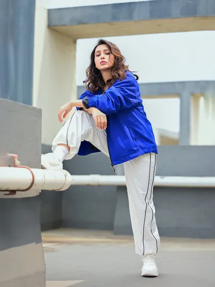 A confident, full-length pose from Mimi's athleisure shoot. The urban rooftop setting and her strong stance complete the modern, street-style narrative.