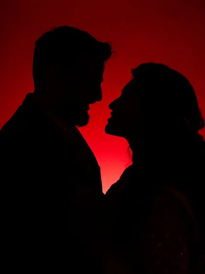 A dramatic silhouette against a bold red backdrop. I love playing with light and shadow to create artistic and powerful couple portraits that feel like a scene from a movie.