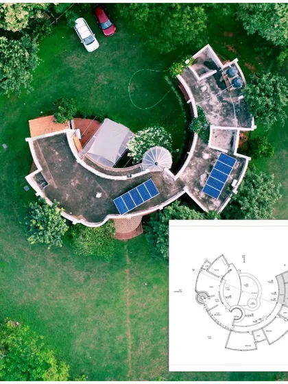 This aerial view showcases one of my favorite projects, a farmhouse in Nelamangala, and demonstrates how I approach design from a macro perspective. The unique, curved structure was designed to sit organically within the verdant landscape. The inclusion of the floor plan shows the meticulous thought process that connects the building's interior flow to the vast outdoor environment.