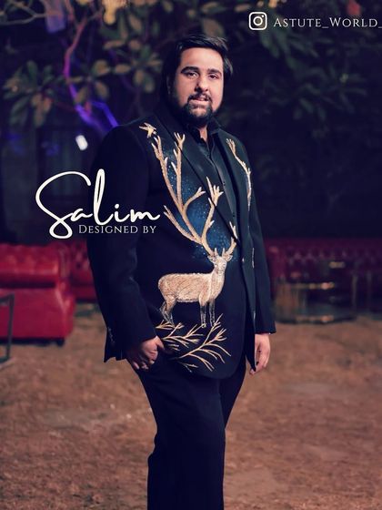A client at an outdoor event in his custom-designed blazer. The hand-embroidered deer with large antlers stands out against the dark fabric, creating a stunning visual.