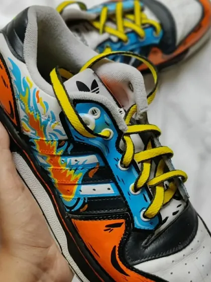 A fiery, sketchy custom on a pair of Adidas sneakers.