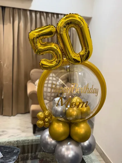 A different angle of the 50th birthday balloon arrangement, showing the layered gold and silver balloons at the base that give it a sturdy and stylish foundation.