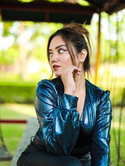 A profile shot of the model looking away, with a focus on her sharp winged eyeliner and the sheen of the bodysuit.