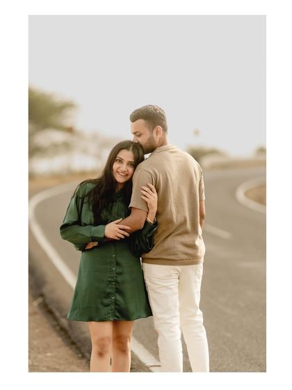 A sweet and simple portrait on an empty road. Her leaning on him with a happy smile is a perfect capture of their love and trust.