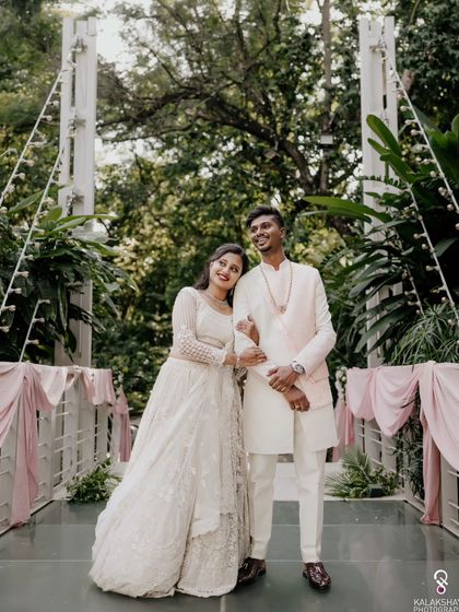 A relaxed and happy portrait of the couple on a bridge at their engagement venue.