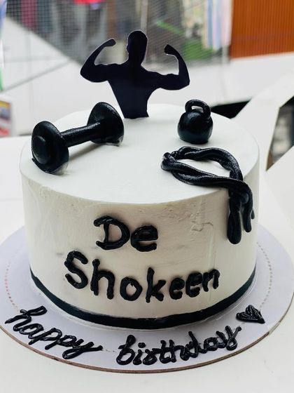 A fitness-themed cake for a gym lover, featuring dumbbells and a silhouette.