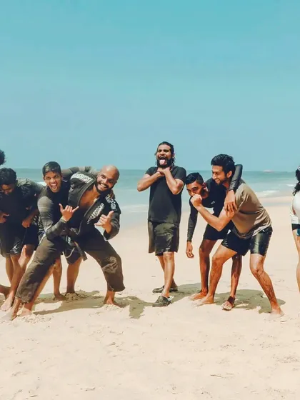 This is the result of a hard day's work. A team forged by shared effort on the sands of the Udupi coast. We mix grappling drills with surfing, pushing our limits and then celebrating the progress together. Everyone, from beginners to advanced practitioners, is part of the crew.