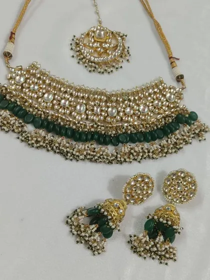 A classic Kundan choker set with green beads and pearl clusters. This rental set includes the necklace, jhumka earrings, and a maang tikka.