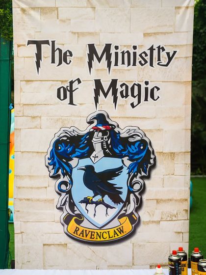A "Ministry of Magic" stall sign featuring the Ravenclaw crest, showing the detailed branding for each activity area.