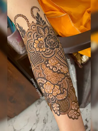 The full forearm design for Arfa, showcasing a beautiful blend of Pakistani and Indian henna styles with roses and intricate fillers.