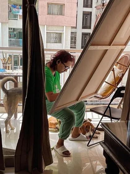 A candid shot of me sketching on the balcony. I'm perpetually surrounded by my dogs, who are my constant companions during my creative process.
