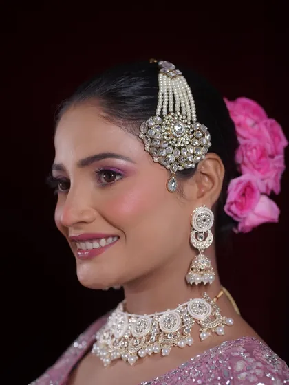 A side profile highlighting the elegant hair accessory and floral bun, which complete the Walima bridal look.