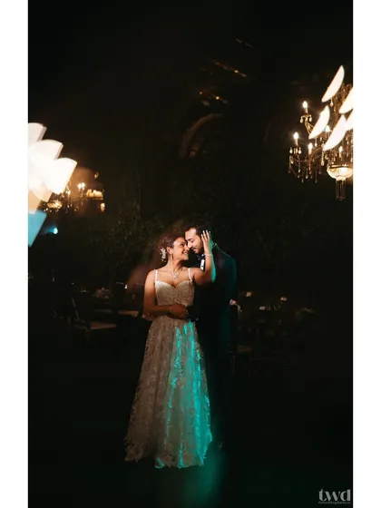 A moody and romantic portrait of the couple under dramatic lighting after their garden wedding ceremony.
