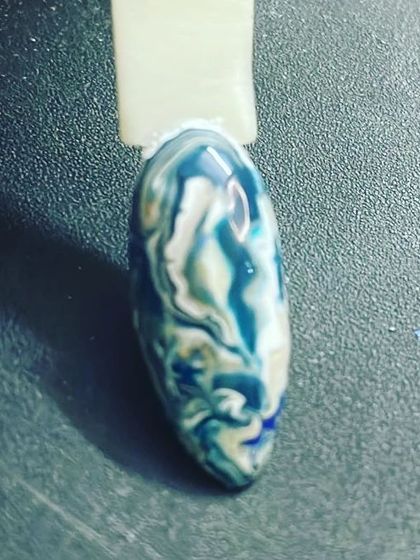 This sample nail shows a beautiful blue and white marble or watercolor effect. It's a great way to create a unique, fluid design where no two nails are exactly alike.