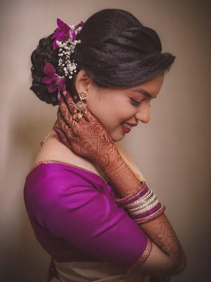 A close-up shot focusing on the bride's intricate mehndi and her happy, blushing expression. These are the details that make engagement photos so special.