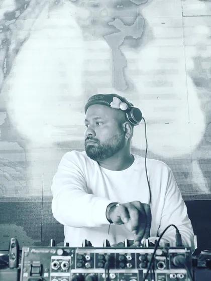 A candid, black and white photo of me at the console, looking out towards the crowd. This shot captures a moment of focus as I plan my next mix.