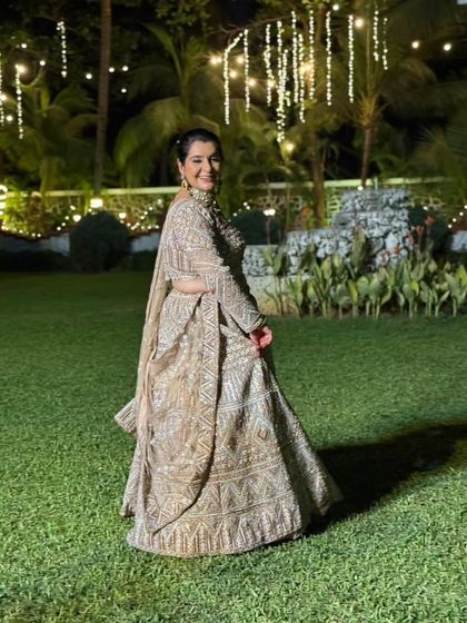 Our client looks absolutely radiant in this embellished beige lehenga, pictured here at an outdoor evening function. The lights make the outfit sparkle even more.