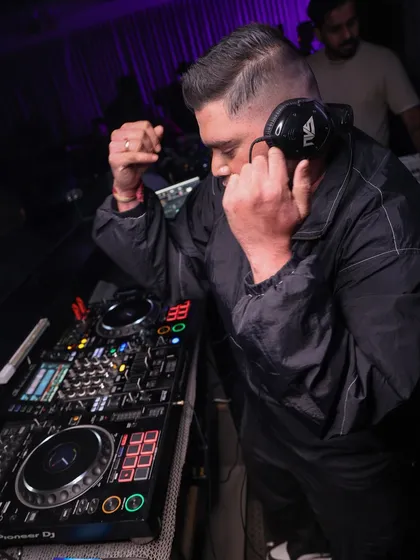 One ear on the headphones, one on the room. This is how I stay connected to both the music and the crowd's reaction.