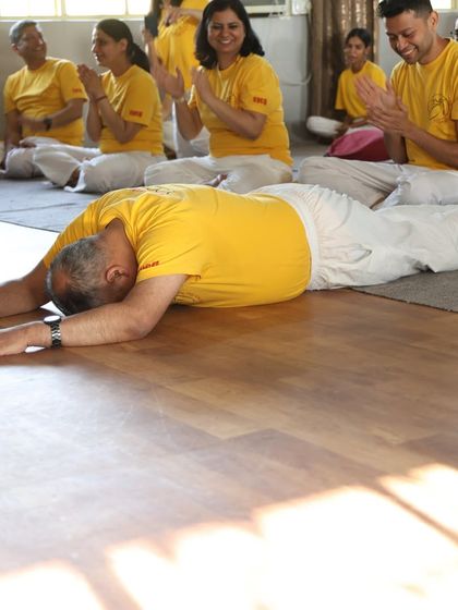 A teacher prostrates before the altar during the graduation ceremony, an act of complete surrender and gratitude to the gurus.