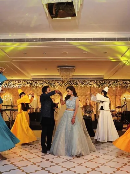 The Sufi dancers create a welcoming gesture for the couple. The combination of graceful movement, vibrant colors, and spiritual music makes for a truly unique and elegant celebration.