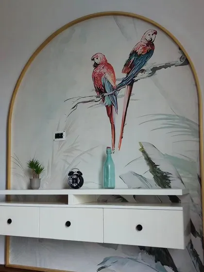 This arched wall feature is enhanced with a delicate wallpaper showing two parrots on a branch. It acts like a custom piece of art, adding a touch of elegance and nature to the room.