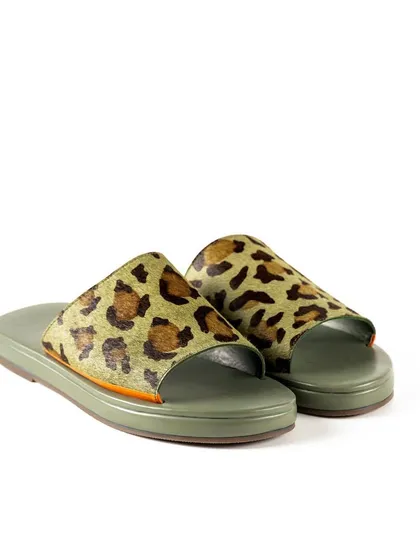 A clean, three-quarter view of Jeetinder Sandhu's leopard print slides. This e-commerce shot on a white background provides a clear and detailed look at the stylish footwear.